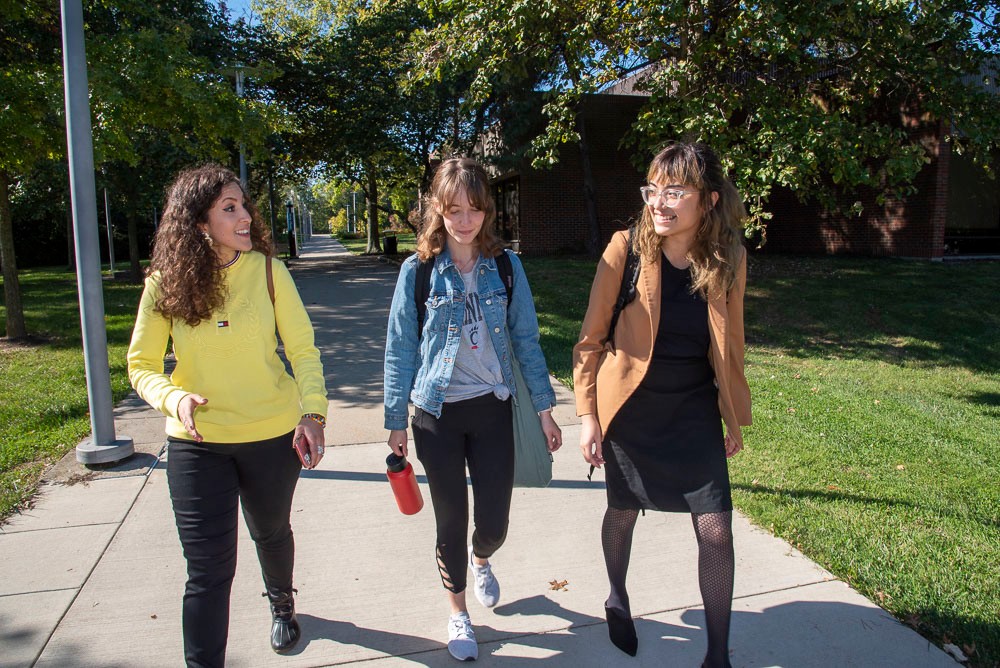 three students walking across campus
