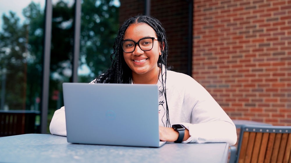 Kelli Walker outside with laptop