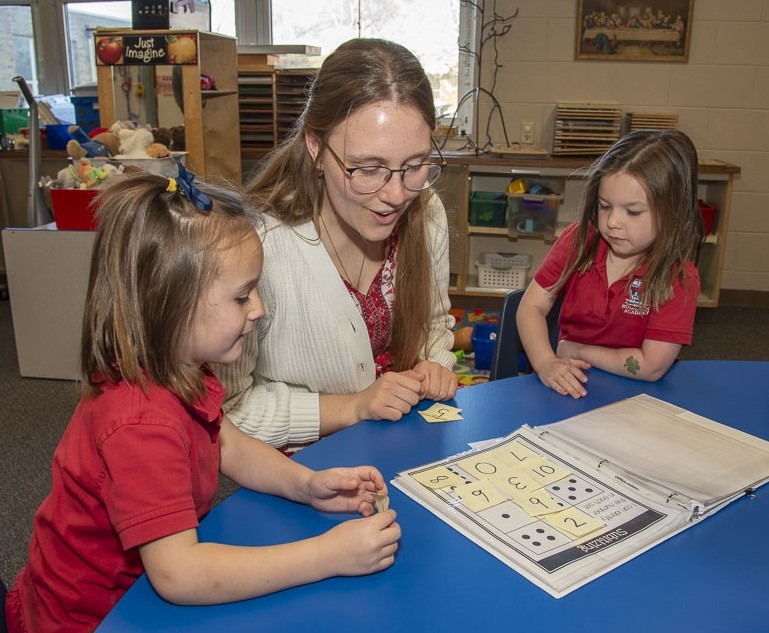 Sophia reading to two young students