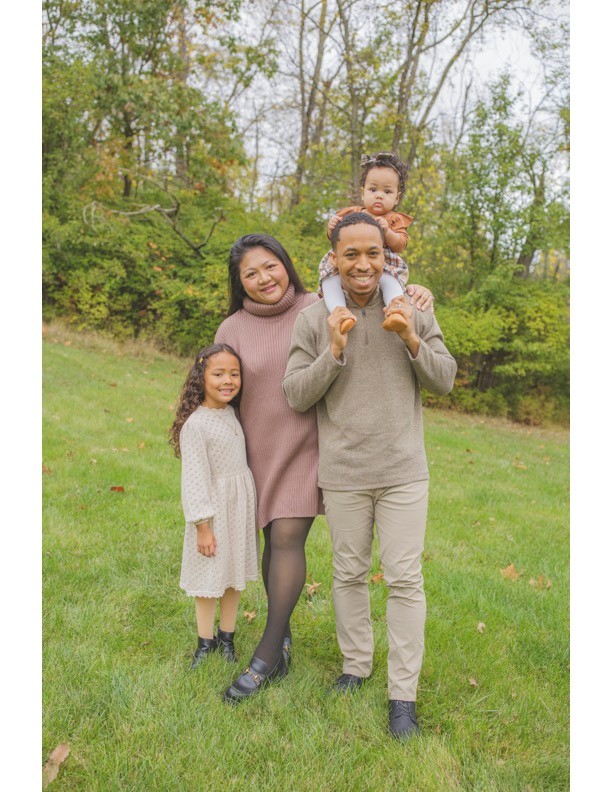 family of four posing outside